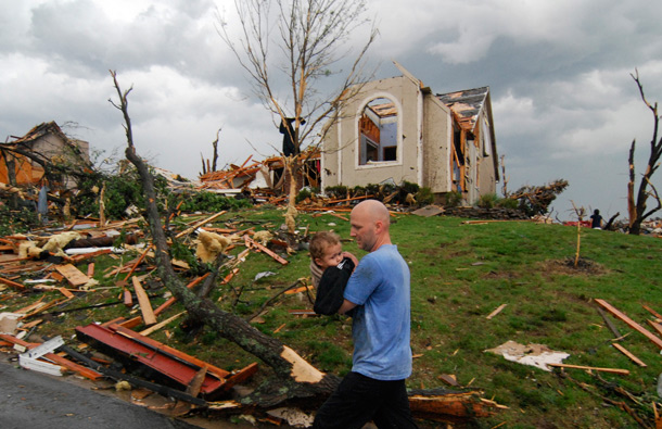 A man carries a young boy who was rescued after being trapped in his home after a tornado hit Joplin, Mo. on Sunday evening. The tornado tore a path a mile wide and four miles long destroying homes and businesses. (AP)