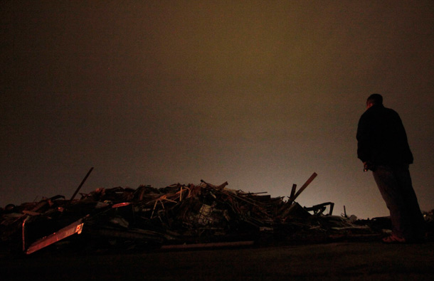 Pepsi Cola employee Mark Johnson looks at the wreckage of the Pepsi Cola Bottling Plant that was destroyed by a tornado in Joplin, Mo. (AP)