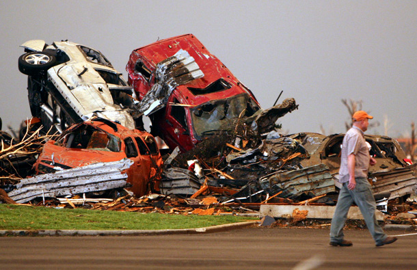 A man walks past destroyed vehicles in the parking lot of the Joplin Regional Medical Center in Joplin, Mo. A large tornado moved through much of the city, damaging the hospital and hundreds of homes and businesses. (AP)