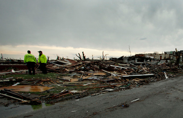 Emergency responders survey a mangled neighborhood in Joplin, Mo. A large tornado moved through much of the city Sunday, damaging a hospital and hundreds of homes and businesses and killing at least 116 people. (AP)