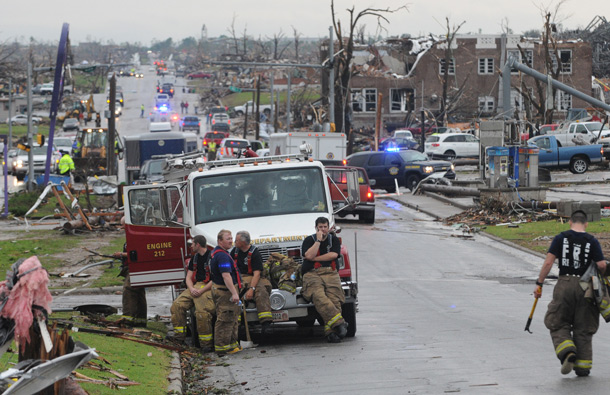 Nevada Missouri firefighters take a break from search and rescue work in Joplin, Mo. Fire and rescue workers from neighboring cities and states have joined the rescue effort from the tornado that struck Joplin on Sunday, May 22. (AP)