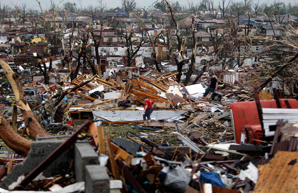 Meghan Miller stands in the middle of a destroyed neighborhood as she checks on her sister-in-law's home, in Joplin, Mo. A large tornado moved through much of the city Sunday, damaging a hospital and hundreds of homes and businesses. (AP)