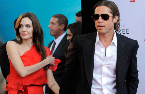 Brad Pitt, a cast member in "The Tree of Life," leads his wife Angelina Jolie by the hand as they arrive at a screening of the film, in Los Angeles. (AP)