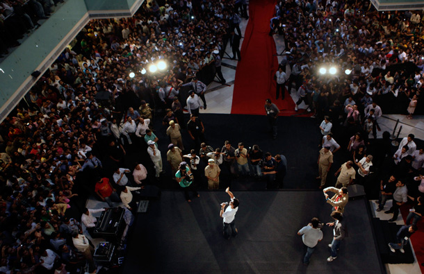 Bollywood actor Shah Rukh Khan, center front in white, greets fans as he arrives at a function to promote his upcoming film Ra.One, in New Delhi, India. Ra.One is a Hindi science fiction superhero film. (AP)