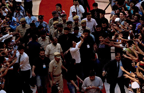 Bollywood actor Shah Rukh Khan, center front in white, greets fans as he arrives at a function to promote his upcoming film Ra.One, in New Delhi, India. Ra.One is a Hindi science fiction superhero film. (AP)