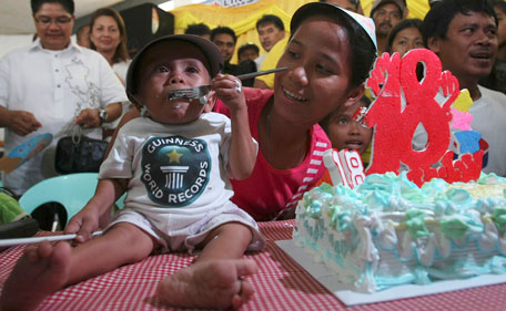 Junrey Balawing eats his cake after he was officially declared "the world's shortest living man" by the Guinness World Records at Sindangan Municipal Hall, Sindangan township, Zamboanga Del Norte province in Southern Philippines, Sunday June 12, 2011, his 18th birthday and coincidentally the Philippines' Independence Day. (AP)
