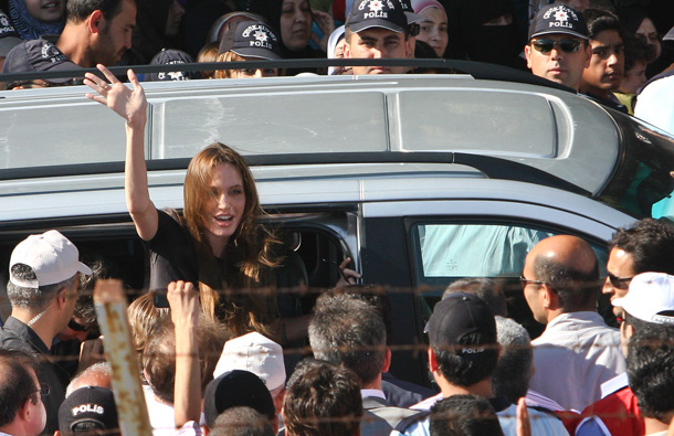 Angelina Jolie, Hollywood actress and goodwill ambassador for the U.N. High Commissioner for Refugees, UNHCR, waves as she exits a van surrounded by Syrian refugees at the Altinozu refugee camp, Turkey, near the Syrian border. UN envoy Angelina Jolie traveled to Turkey's border with Syria to meet some of the thousands of Syrian refugees. (AP)