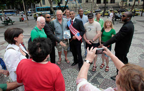 US President Barack Obama impersonator, Rinaldo Americo, poses with tourists in Cinelandia Square in Rio de Janeiro. (REUTERS)