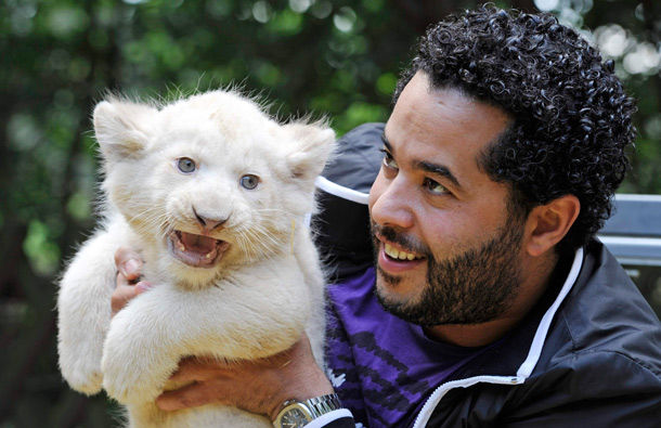 Adel Tawil, a singer with the German band "Ich&Ich", poses with a six-week-old white lion cub named "Adel" after a christening ceremony for three white lions in a safari-park in Hodenhagen, Lower-Saxony. (REUTERS)