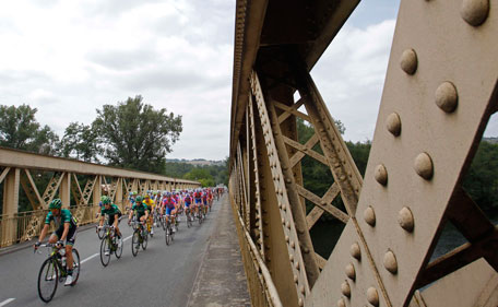 The pack with Thomas Voeckler of France, wearing the overall leader's yellow jersey, crosses a bridge during the 10th stage of the Tour de France cycling race over 158 kilometers (98.2 miles) starting in Aurillac and finishing in Carmaux, south central France, Tuesday July 12, 2011. (AP)