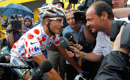 Journalists crowd around Johnny Hoogerland of The Netherlands, wearing the best climber's dotted jersey, prior to the start of the 10th stage of the Tour de France cycling race over 158 kilometers (98.2 miles) starting in Aurillac and finishing in Carmaux, south central France, Tuesday July 12, 2011. Hoogerland was victim of a crash after a vehicle hit riders in the breakaway group during the 9th stage. (AP)