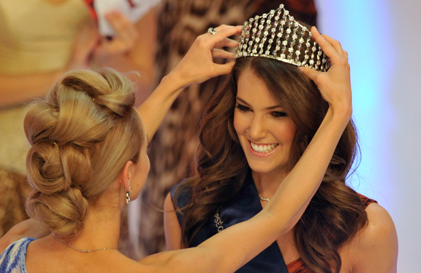 Miss Hungary 2010 Agnes Dobo, left, passes her crown to Linda Szunai, 19-year old student, who smiles after winning the Miss Hungary beauty contest in Budapest, Hungary. Linda Szunai will represent Hungary on the upcoming Miss World final in London. (AP)