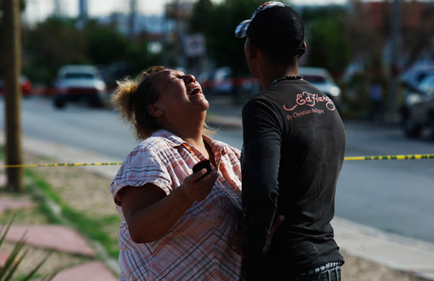 A woman reacts at a crime scene in Ciudad Juarez. Municipal policemen detained four hitmen just minutes before they killed two men and injured a woman and her son outside a clinic, local media reported. (REUTERS)