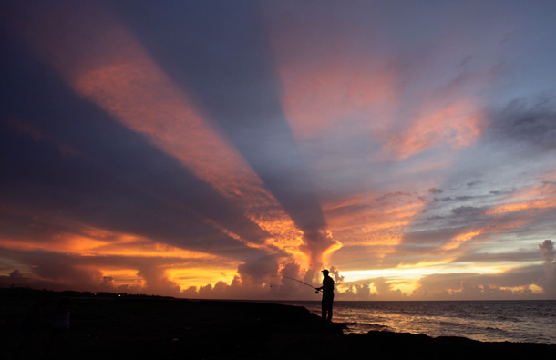 A fisherman casts his line as the sun sets on the outskirts of Havana. (REUTERS)