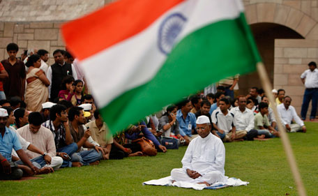 Indian flag is seen in the foreground as rights activist Anna Hazare sits in a meditative posture at Rajghat, the Mahatma Gandhi memorial in New Delhi, India, Monday, Aug. 15, 2011. The activist was detained by police at his home on Tuesday to prevent him from defying authorities with a fast to the death to force tougher laws against corruption (AP)