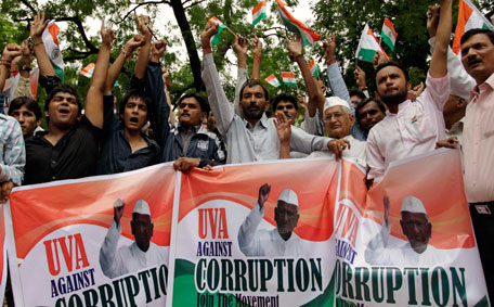 Supporters of Indian rights activist Anna Hazare hold banners with his photographs and shout slogans as they stage a demonstration in his support in Ahmedabad, India, Monday, Aug. 15, 2011. (AP)