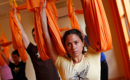 Students take part in an "antigravity" yoga class at the Om Factory in New York August 16, 2011. "Antigravity" yoga makes use of hammocks to help practitioners gain greater flexibility, allowing for a wider range of yoga poses, according to the workshop's website.(REUTERS)