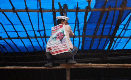 A supporter of veteran Indian social activist Anna Hazare climbs a bamboo tent structure while attending a protest rally against corruption in Mumbai August 16, 2011. Police arrested Hazare on Tuesday, just hours before he was due to begin a fast to the death, as the beleaguered government cracked down on a self-styled Gandhian activist agitating for a new "freedom" struggle. (REUTERS)