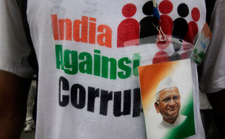 A supporter wears a picture of Indian rights activist Anna Hazare at the site where he was detained prior to beginning a hunger strike in New Delhi, India, Tuesday, Aug 16, 2011. The prominent activist who had announced an indefinite hunger strike to demand tougher anti-corruption laws was detained early Tuesday morning, police said. (AP)