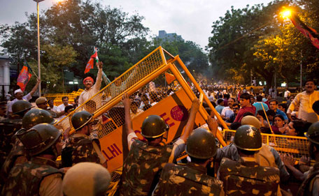 Policemen try to put back police barricades removed by opposition Bharatiya Janata Party activists protesting the arrest of Indian anti-corruption activist Anna Hazare in New Delhi, India, Tuesday, Aug 16, 2011.Hazare, arrested Tuesday for planning a public hunger strike , began his fast behind bars as his supporters held protests across the country, with thousands detained by police. (AP)