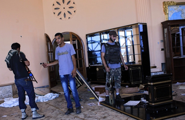 Rebel fighters walk inside the house of Al-Saadi Gaddafi. (AP)