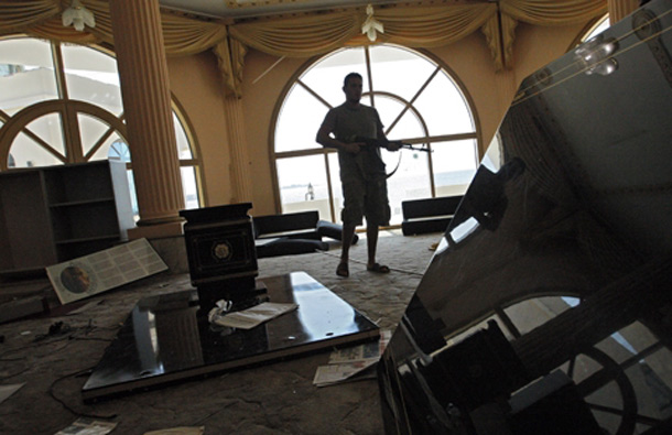 A rebel fighter walks inside the house of Al-Saadi Gaddafi, the son of Libyan dictator Moammar Gadhafi in Tripoli, LIbya. (AP)