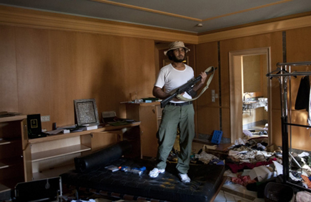 A rebel fighter stands on a bed in the house of Aisha Gaddafi. (AP)