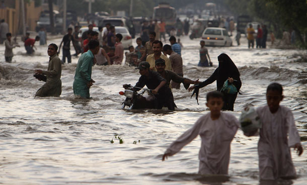 Pakistanis wade through a flooded road caused by heavy monsoon rainfall in Karachi, Pakistan on Saturday, Sept 10, 2011. (AP)