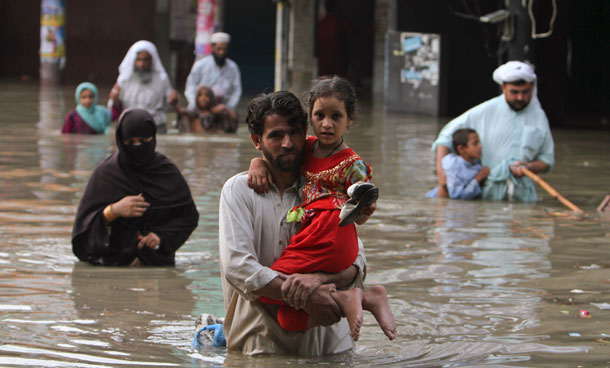 Pakistani families wade through a flooded area caused by heavy monsoon rainfall in Karachi, Pakistan on Saturday, Sept 10, 2011. (AP)