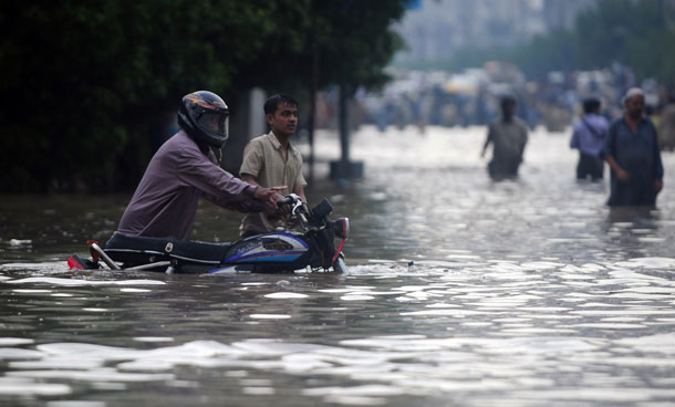 A commuter pushes his motorcycle through floodwaters in Karachi on September 10, 2011. Six people including two women and a minor were electrocuted and more than two dozens injured in different parts of the city as heavy downpour lashed the metropolis afternoon, paralysing the communication and power supply network as more than 100 feeders of Karachi Electric Supply Company (KESC) tripped off the system. (AFP)