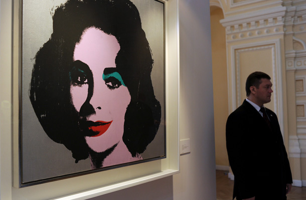 A man stands at "Silver Liz" by Andy Warhol displayed at Elizabeth Taylor's jewelry public exhibition  in GUM on Moscow's Red Square, on September 14, 2011, shortly after the exhibition opening. (AFP)