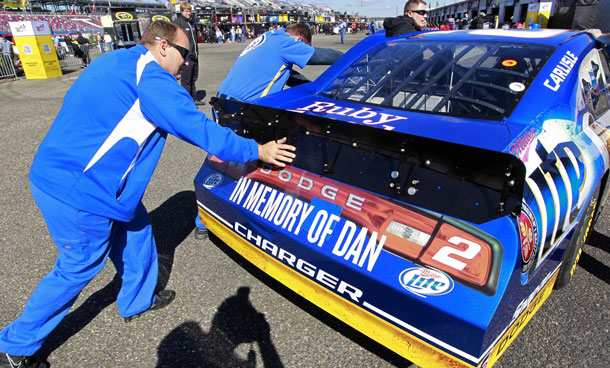 Scott Elerridge, a crew member for Sprint Cup Series driver Brad Keselowski (2), pushes the car through the garage area after inspection at the Talladega Superspeedway in Talladega, Ala, Friday, Oct 21, 2011.  The car carries a tribute to Dan Wheldon who was killed during an Indy car race last Sunday in Las Vegas. (AP)