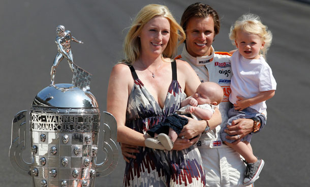 In this May 30, 2011 file photo, IndyCar driver Dan Wheldon, of England, poses with his family, wife Susie, left, holding Oliver, and Sebastian, right, next to the Borg-Warner Trophy. Wheldon died Sunday, Oct 16, 2011 in a fiery 15-car wreck at Las Vegas Motor Speedway when his car flew over another and smashed into the wall. He was 33. (AP)