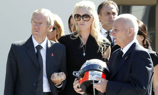 Clive Wheldon, right, father of IndyCar driver Dan Wheldon, holds his son's helmet as Dan's wife Susie, center, and her father Sven Behm, left, watch as Dan Wheldon's coffin is placed in a hearse after funeral services Saturday, Oct 22, 2011, in St Petersburg, Fla.  Dan Wheldon was killed on Sunday, Oct 16, 2011, in a fiery 15-car crash at the Las Vegas Motor Speedway. (AP)