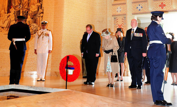 Britain's Queen Elizabeth II (3rd R) is accompanied by General Peter Cosgrove (2nd R) as she observes a minute's silence at the Tomb of the Unknown Soldier at the Australian War Memorial in Canberra on October 25, 2011. Loud cheers from well-wishers greeted the queen when she had finished her sombre remembrance of Australia's fallen soldiers. (AFP)