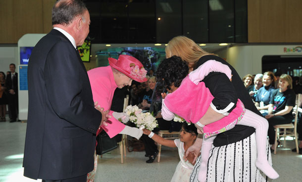 Queen Elizabeth II receives flowers from previously conjoined twin Trishna as her guardian Miora Kelly holds her sister Krishna at the opening of the new Royal Children's Hospital on October 26, 2011 in Melbourne, Australia. (GETTY)