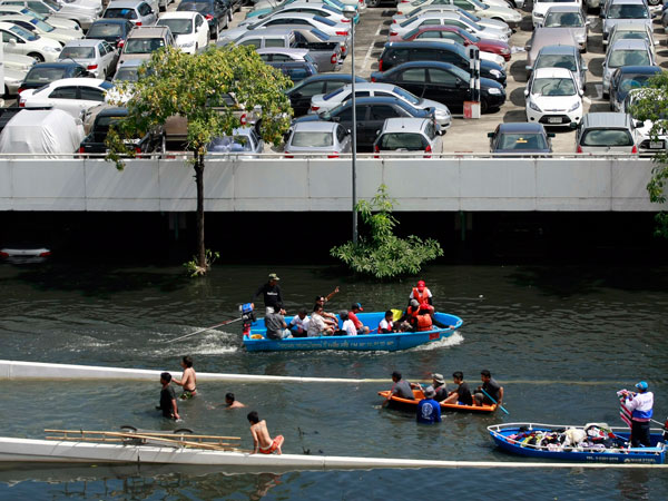 Thai flood victims who took shelter at Don Muang airport swim in the floodwater next to a parking ramp in Bangkok, Thailand Wednesday, Nov. 2, 2011. (AP)