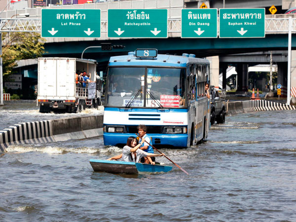 Residents row a boat in front of a bus along a flooded street in Bangkok November 7, 2011. (REUTERS)