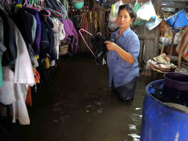 A Thai woman prepares to dry her clothes in floodwaters at her home along the Chao Praya river in Bangkok on November 2, 2011. (AFP)