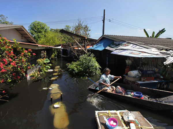 A Thai flood victim salvages some of her belongings from her house submerged in floodwaters on the outskirts of Bangkok, Thailand, Wednesday, Nov. 2, 2011. (AP)