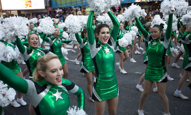 Cheerleaders march through Times Square during Macy's Thanksgiving Day parade on November 24, 2011 in New York City. The 85th annual event is the second oldest Thanksgiving Day parade in the US. (AFP)