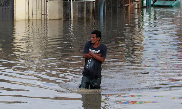 A man walks in a flooded street in Cali December 5, 2011. At least 96 people have died as a result of heavy rains, authorities said. Colombia's weather office expects La Nina-related downpours to continue at least until the end of the first quarter of next year. (REUTERS)