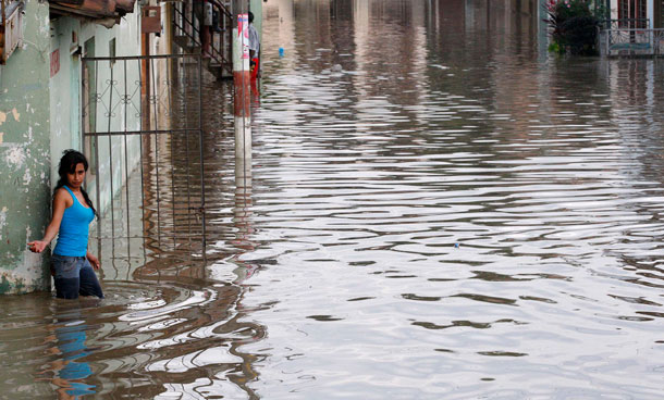 A woman walks in a flooded street in Cali December 5, 2011. At least 96 people have died as a result of heavy rains, authorities said. Colombia's weather office expects La Nina-related downpours to continue at least until the end of the first quarter of next year. (REUTERS)