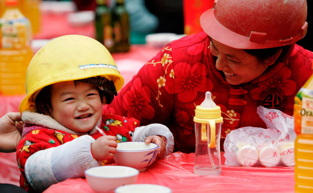 A child has a meal with her family at a local construction site in Chengdu, Sichuan province January 9, 2012. More than 1,400 migrant workers took part in the annual meal to celebrate the upcoming Chinese New Year. The Lunar New Year, or Spring Festival, begins on January 23 and marks the start of the Year of the Dragon, according to the Chinese zodiac. (REUTERS)