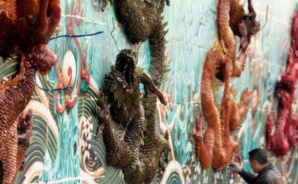 A worker paints the background of a wall, installed with nine sugar dragons, during preparation work for the upcoming Lunar New Year at a park in Chengdu, Sichuan province January 17, 2012. The Lunar New Year, or Spring Festival, begins on January 23 and marks the start of the Year of the Dragon, according to the Chinese zodiac. (REUTERS)