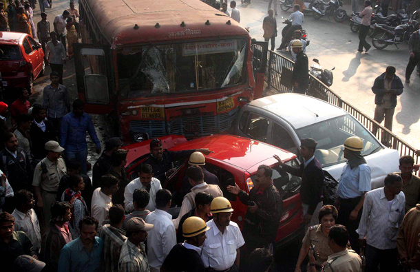 Police and locals gather near the accident site where nine people were killed and 27 injured when a bus driver went on a rampage in the western Indian city of Pune, Maharastra, 25 January 2012  ramming vehicles and hitting pedestrians. At least 40 vehicles were damaged. The 27 injured have been admitted to three hospitals in the city.