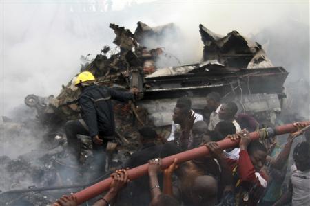 People help rescue workers lift a water hose to extinguish a fire after a plane crashed into a neighbourhood in Ishaga district, an outskirt of Nigeria's commercial capital Lagos June 3, 2012. (REUTERS)