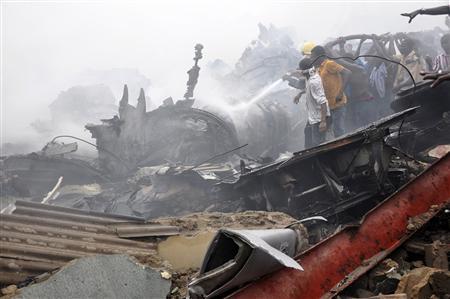 Emergency workers and volunteers hose down wreckage at the scene of a plane crash in Nigeria's commercial capital Lagos, June 3, 2012. (REUTERS)