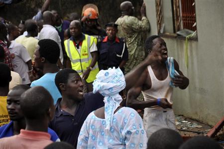 People react at the scene of a plane crash in Nigeria's commercial capital Lagos, June 3, 2012. A passenger plane carrying nearly 150 people crashed into a densely populated part of Lagos on Sunday, in what looked like a major disaster in Nigeria's commercial hub. There was no early word from airline or civil aviation authority officials in the West African country on casualties. (REUTERS)