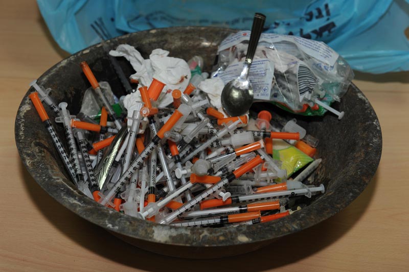 Some the needles and drugs found in the water tank on the rooftop of the arrested youth's house.